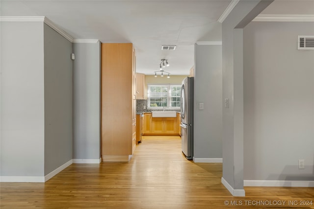 corridor with crown molding, sink, and light wood-type flooring