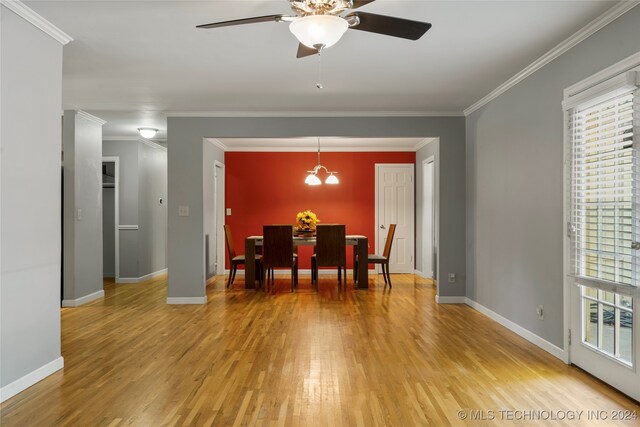 dining area with ornamental molding, wood-type flooring, and ceiling fan with notable chandelier