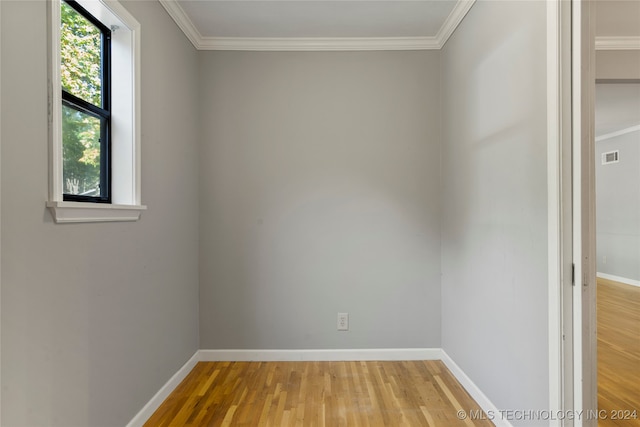 unfurnished room featuring crown molding and light wood-type flooring