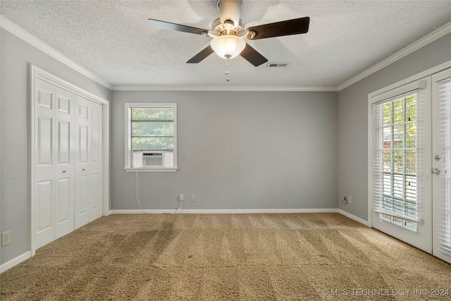 carpeted spare room with ornamental molding, a textured ceiling, a healthy amount of sunlight, and ceiling fan