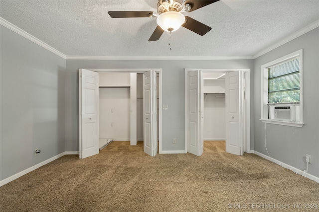 unfurnished bedroom with multiple closets, ornamental molding, carpet flooring, a textured ceiling, and ceiling fan