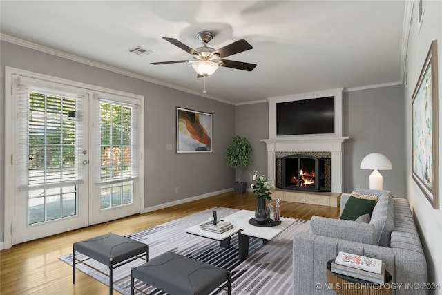 living room with ornamental molding, a fireplace, and hardwood / wood-style floors