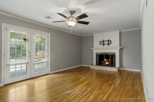 unfurnished living room with light hardwood / wood-style flooring, crown molding, a fireplace, and ceiling fan