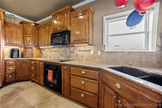 kitchen with crown molding, light stone countertops, backsplash, and black appliances