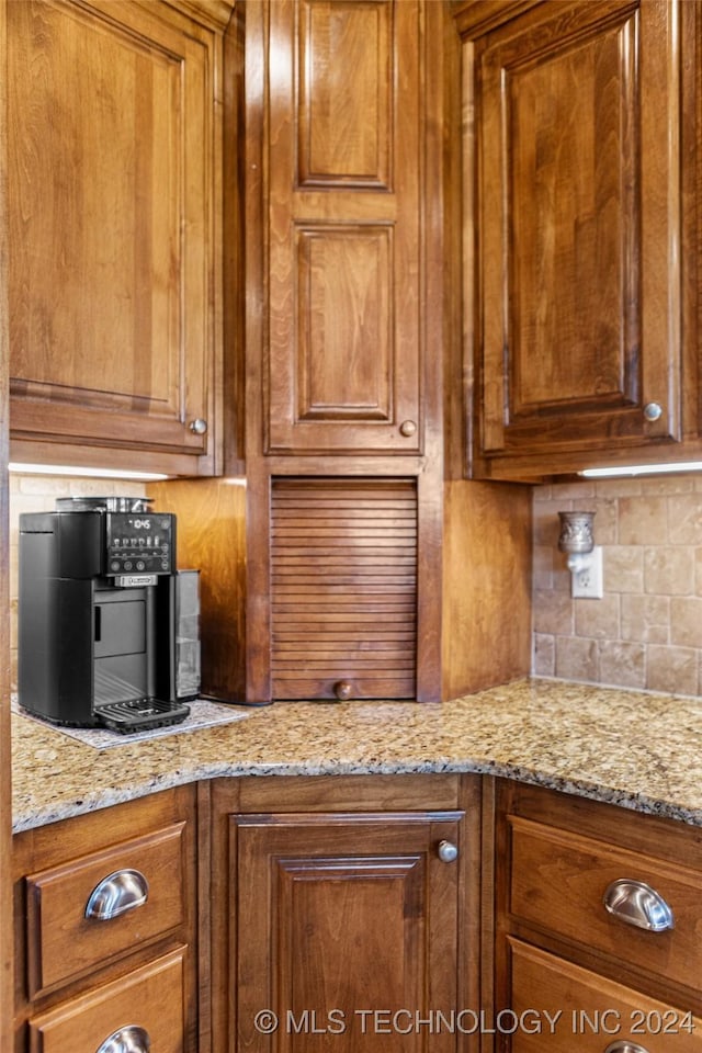 kitchen with light stone countertops and decorative backsplash