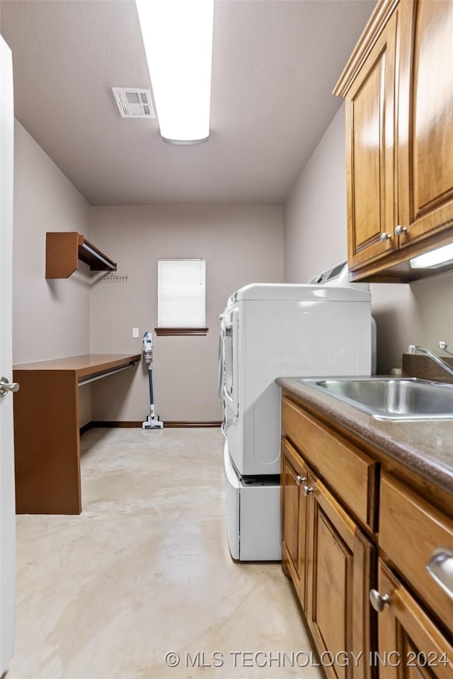 washroom with cabinets, washer / dryer, and sink