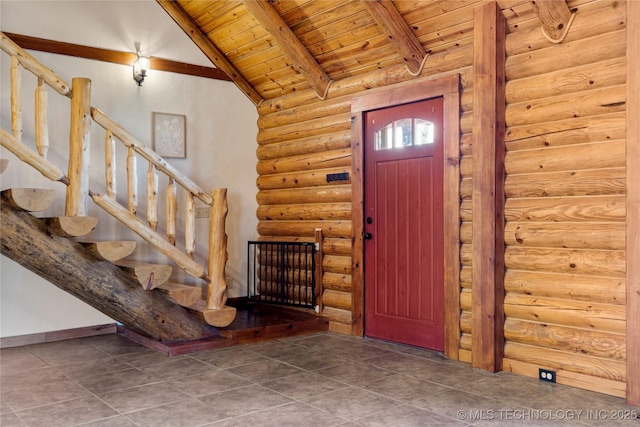 entryway with lofted ceiling with beams, wooden ceiling, and rustic walls