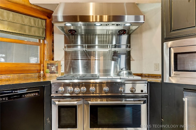 kitchen with appliances with stainless steel finishes, light stone countertops, and wall chimney range hood