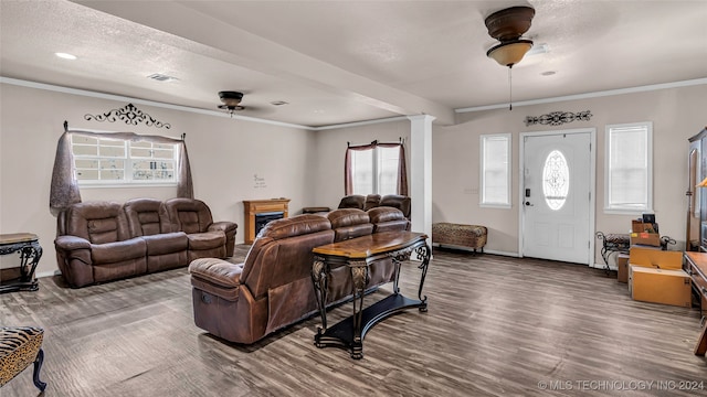 living room with a textured ceiling, ornate columns, ceiling fan, crown molding, and hardwood / wood-style flooring