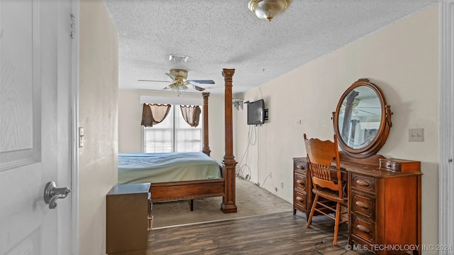 bedroom with ceiling fan, a textured ceiling, and dark hardwood / wood-style flooring