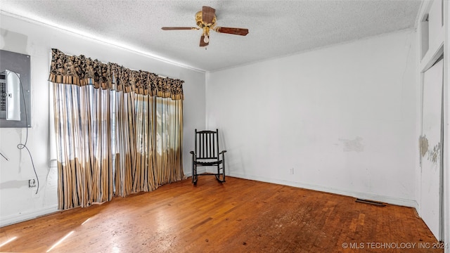 unfurnished room with a textured ceiling, wood-type flooring, and ceiling fan