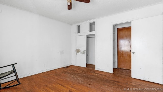 bedroom featuring dark wood-type flooring, a textured ceiling, a closet, and ceiling fan