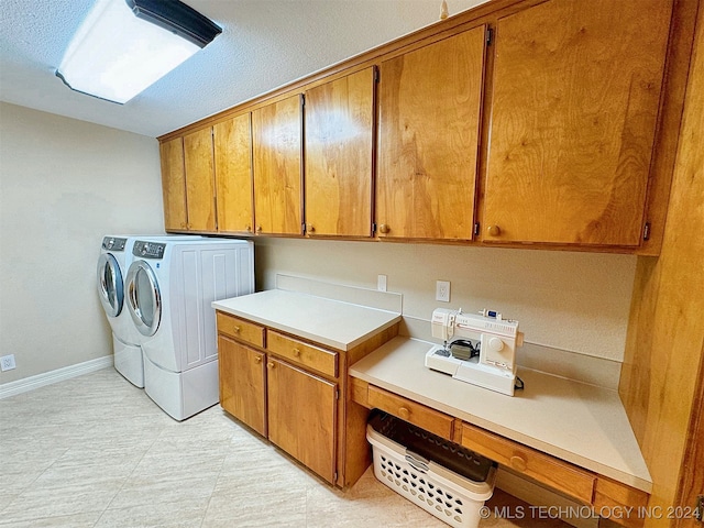 laundry room with cabinets, a textured ceiling, and washing machine and clothes dryer