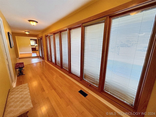 hallway with light hardwood / wood-style floors