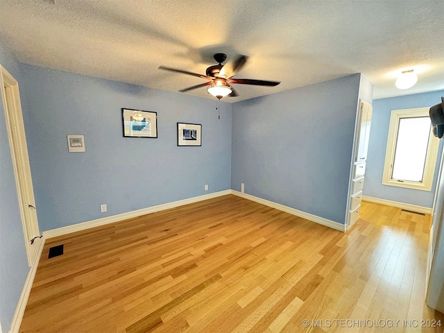 unfurnished room featuring light hardwood / wood-style flooring, a textured ceiling, and ceiling fan