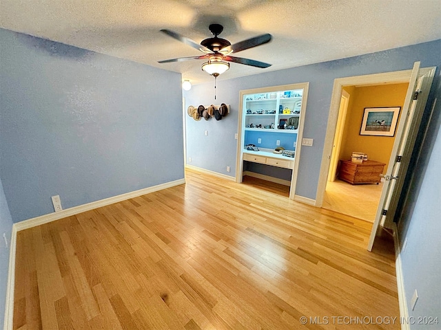 interior space featuring hardwood / wood-style floors, a textured ceiling, and ceiling fan