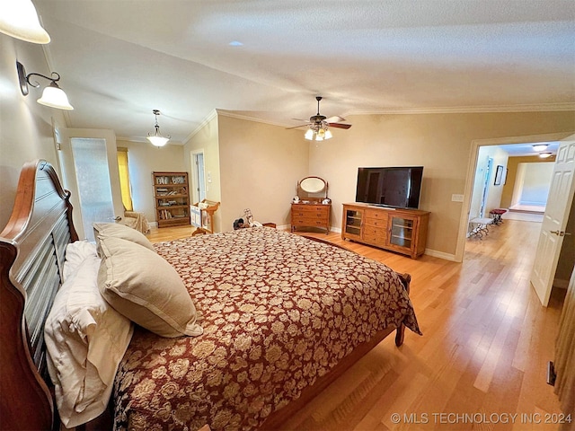 bedroom featuring ornamental molding, vaulted ceiling, light wood-type flooring, and ceiling fan