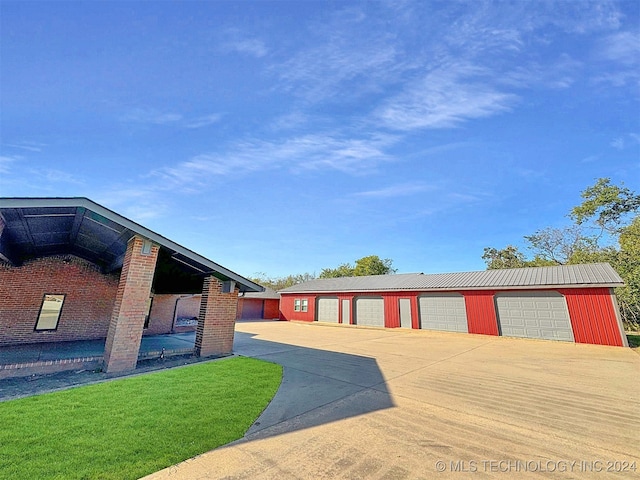 exterior space with a front yard, an outbuilding, and a garage