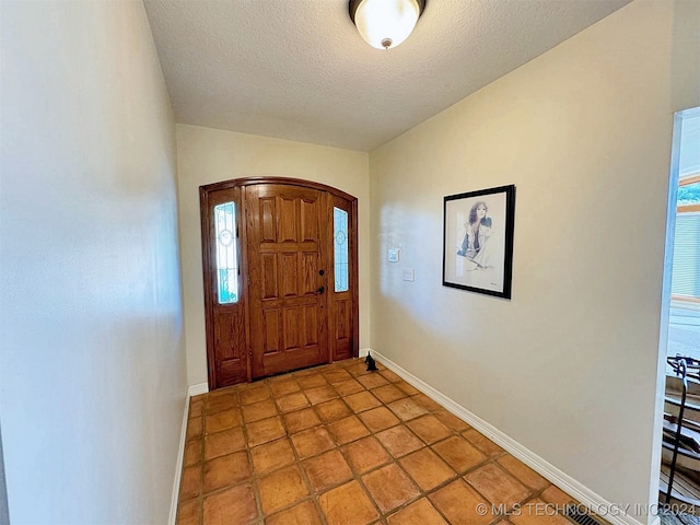 tiled foyer with a textured ceiling and a wealth of natural light