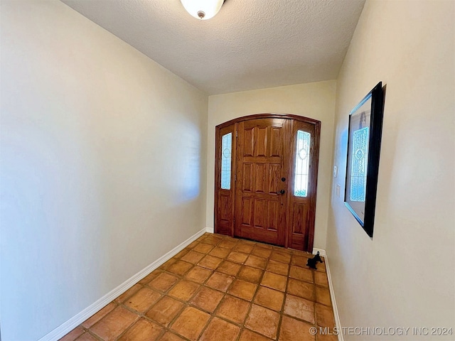 foyer entrance with a textured ceiling