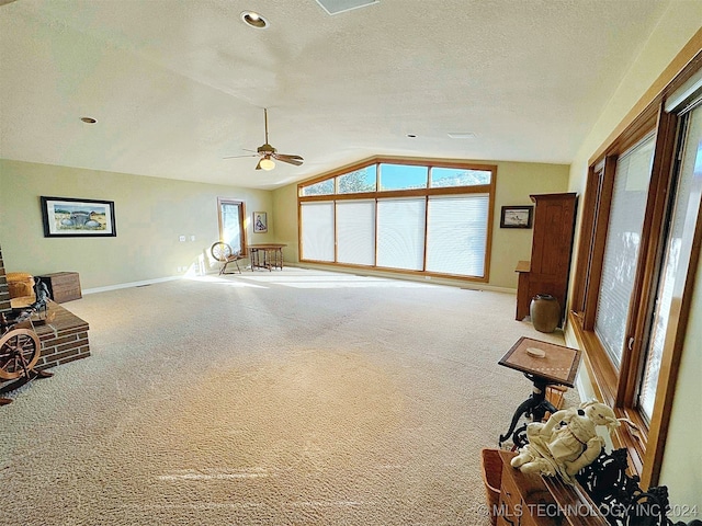 living room featuring lofted ceiling, carpet, a textured ceiling, and ceiling fan