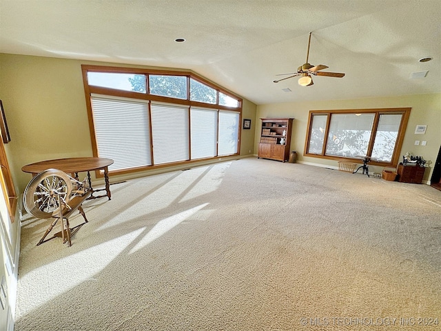 unfurnished living room featuring lofted ceiling, carpet flooring, and ceiling fan