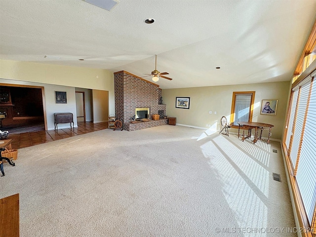 unfurnished living room featuring ceiling fan, carpet flooring, lofted ceiling, and a fireplace