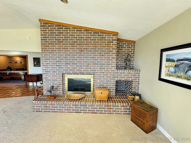 carpeted living room featuring a textured ceiling, a fireplace, and vaulted ceiling