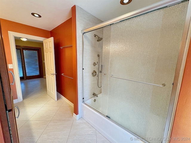 bathroom with tile patterned floors and bath / shower combo with glass door