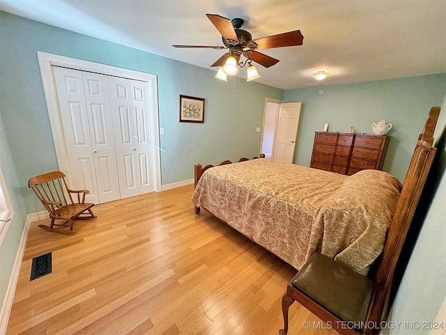 bedroom with a closet, ceiling fan, and light wood-type flooring