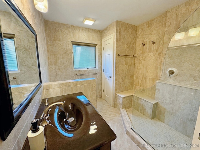 bathroom with vanity, tile walls, and tiled shower