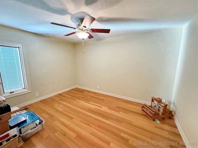 empty room with a textured ceiling, hardwood / wood-style flooring, and ceiling fan