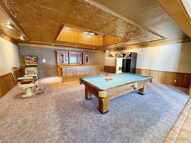 recreation room with ornamental molding, wooden walls, carpet floors, and brick wall