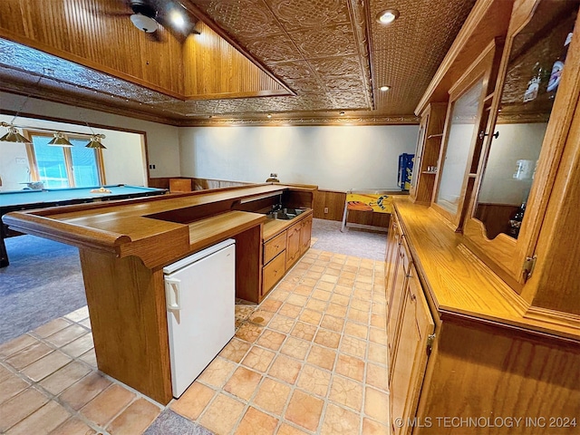 kitchen featuring white fridge, ceiling fan, ornamental molding, and light colored carpet