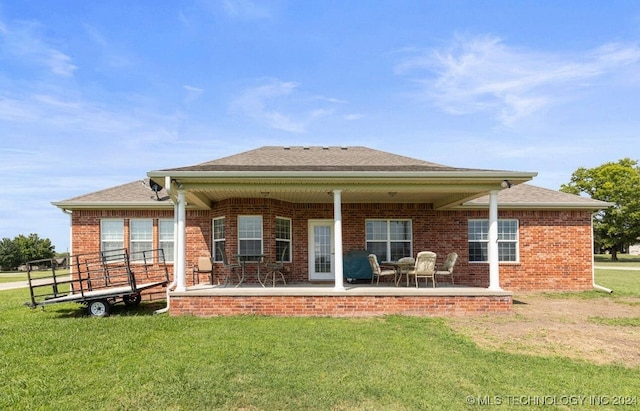 rear view of property featuring a yard and a patio