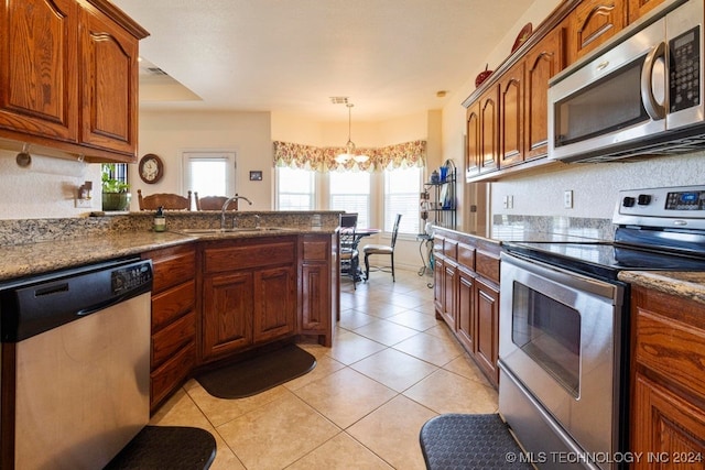 kitchen with an inviting chandelier, light tile patterned flooring, stainless steel appliances, sink, and decorative light fixtures