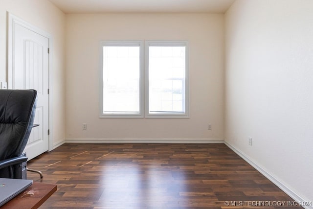 unfurnished office with dark hardwood / wood-style floors