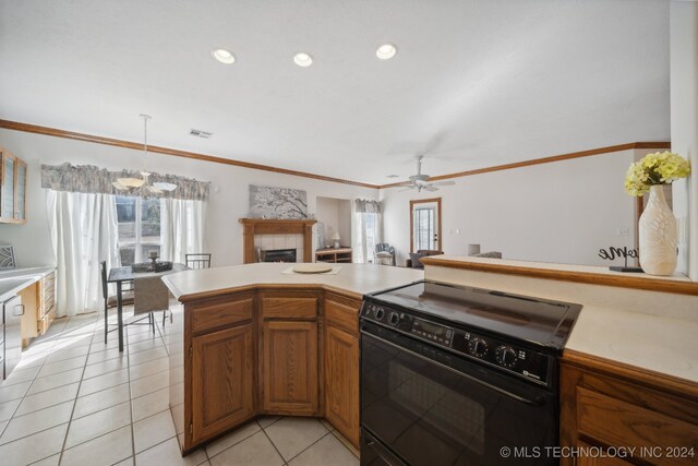 kitchen with a tile fireplace, black range with electric cooktop, crown molding, light tile patterned flooring, and pendant lighting