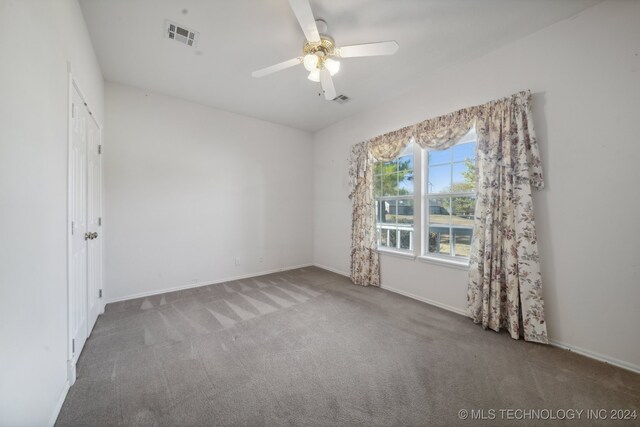 carpeted spare room featuring ceiling fan