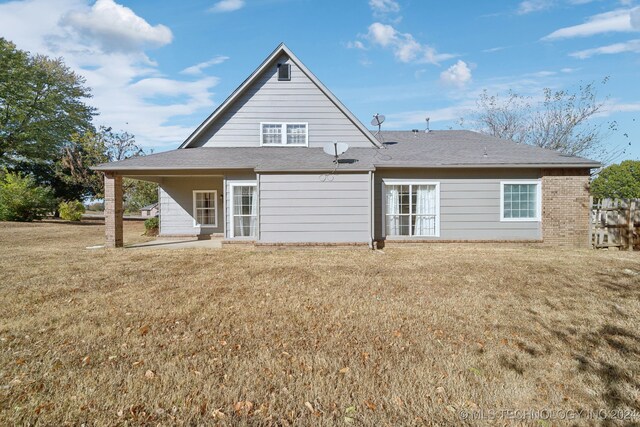 back of property featuring a yard and a patio