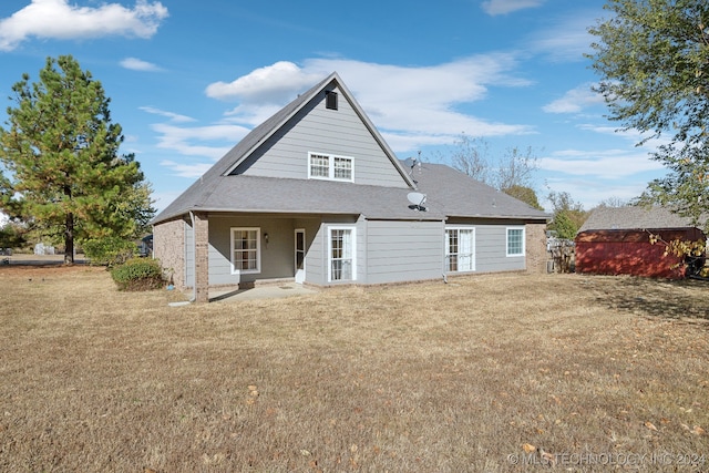 rear view of property with a shed and a lawn