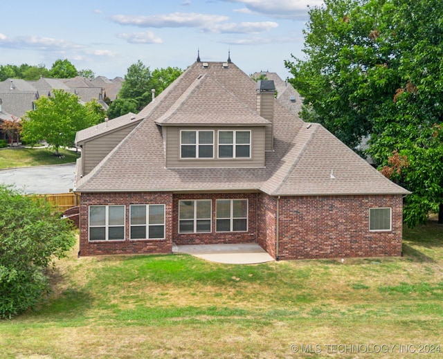 back of house with a patio area and a lawn