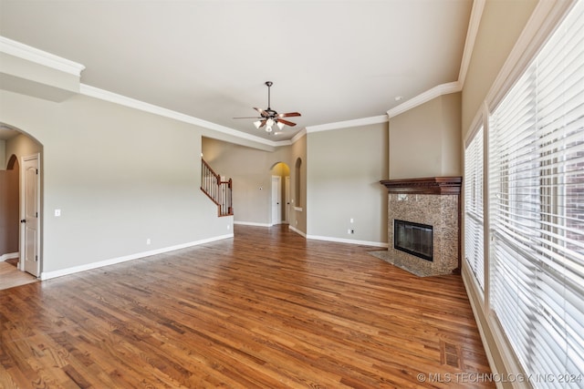 unfurnished living room featuring ceiling fan, crown molding, a fireplace, and hardwood / wood-style floors