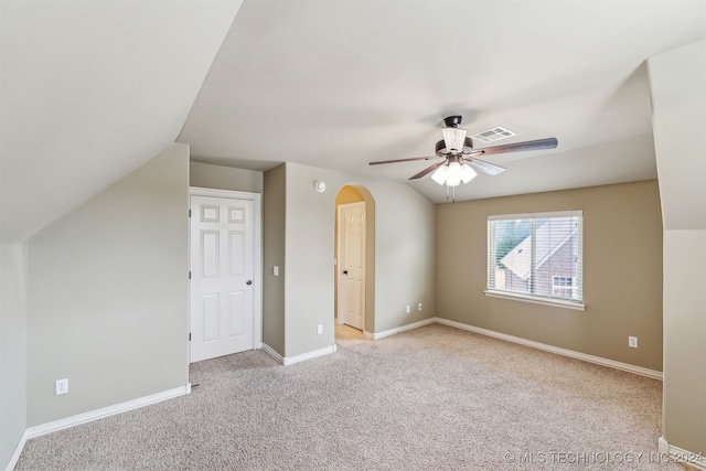 additional living space featuring vaulted ceiling, light colored carpet, and ceiling fan