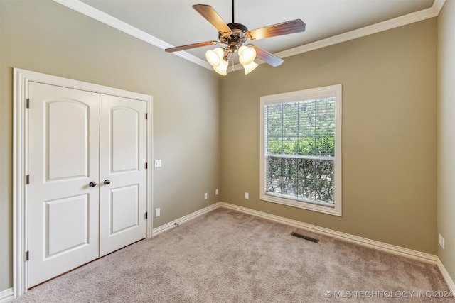 spare room with crown molding, light colored carpet, and ceiling fan