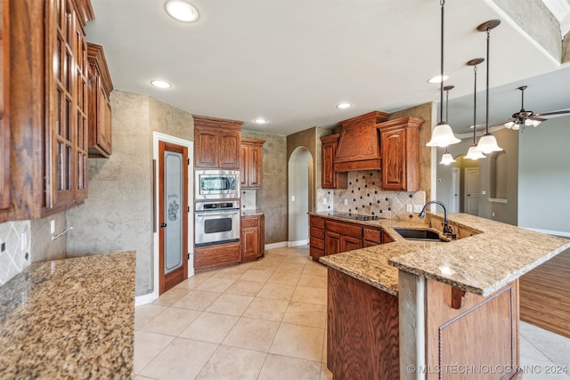 kitchen featuring appliances with stainless steel finishes, sink, kitchen peninsula, decorative light fixtures, and custom range hood