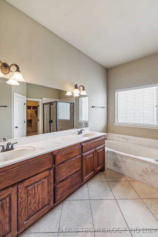 bathroom with vanity, independent shower and bath, a wealth of natural light, and tile patterned flooring