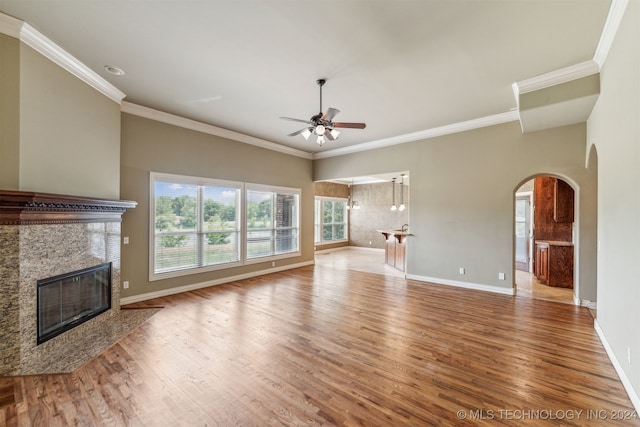 unfurnished living room featuring ornamental molding, a high end fireplace, hardwood / wood-style flooring, and ceiling fan