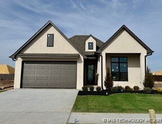 view of front of house featuring a garage and a front lawn