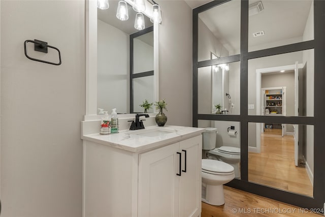 bathroom featuring vanity, hardwood / wood-style flooring, and toilet